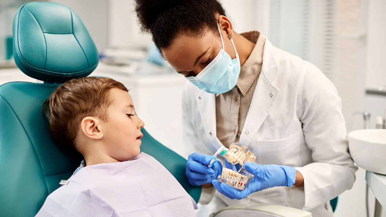 Female dentist talking to her child patient